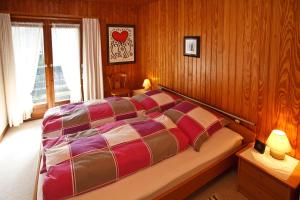 een slaapkamer met een bed met houten wanden en een raam bij Am Traunufer Anneliese Plenk inkl. Chiemgaukarte in Ruhpolding