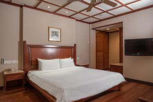 a bedroom with a bed and a flat screen tv at Berjaya Tioman Resort in Tioman Island