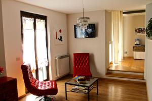 a living room with two red chairs and a table at Albergo Al Castello in Gavi