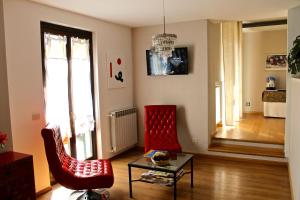 una sala de estar con 2 sillas rojas y una mesa. en Albergo Al Castello, en Gavi