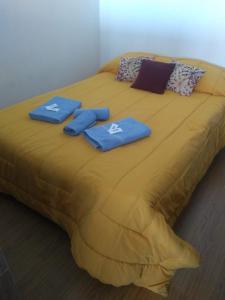 a large yellow bed with two blue towels on it at Departamento Bahía Grande in Ushuaia