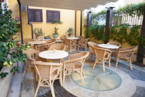 un patio avec des tables et des chaises dans un restaurant dans l'établissement Hotel Windrose, à Rome