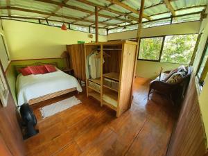 um quarto com uma cama e uma cadeira num quarto em Cabina Gan Eden - Walking distance from river em Portalón