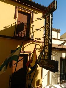 un cartello per un ristorante con bandiere di fronte a un edificio di Plaza de Toros a Ronda