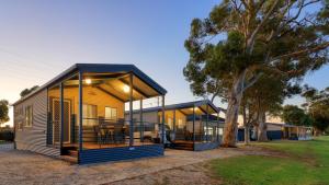 a modular home with large windows and a tree at Lake Boga Caravan Park in Lake Boga