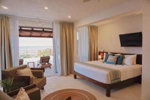 Noah Beach Hotel & Suites في ماهاهوال: غرفة نوم مع سرير وغرفة معيشة
