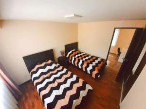 two beds in a living room with brown and white stripes at Zona Sur - Acogedor departamento completo - URBEANDINA in La Paz