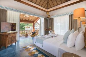 a bedroom with a large bed and a television at Arkana Village Canggu by Nagisa Bali in Canggu +49 photos