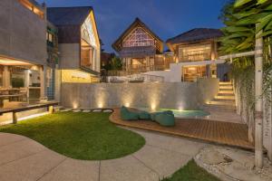 a house with a backyard with a lawn at Arkana Village Canggu by Nagisa Bali in Canggu