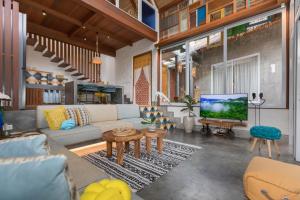 a living room with a couch and a tv at Arkana Village Canggu by Nagisa Bali in Canggu