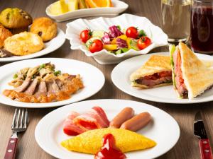 una mesa con platos blancos de comida. en Shin Yokohama Prince Hotel, en Yokohama