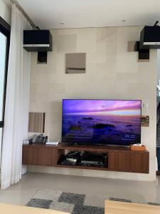 ein großer Flachbildfernseher an einer Wand in einem Wohnzimmer in der Unterkunft Platinum Dago Resort villa 15px Private Pool Bandung in Bengkok + 14 Fotos