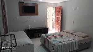 um quarto com uma cama e uma televisão na parede em Flat Santa Maria em Fortaleza