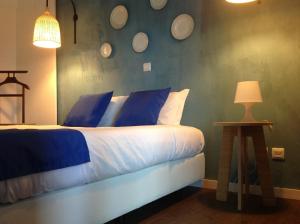 a bedroom with a bed with blue and white pillows at Vilaportuguesa in Vila Velha de Ródão