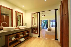 ein Badezimmer mit zwei Waschbecken und einem großen Spiegel in der Unterkunft Mimosa Resort & Spa in Mae Nam