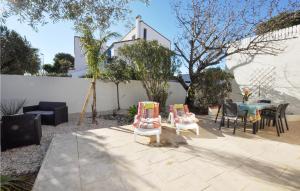 un patio con sedie e un tavolo in un cortile di Holiday Home Canet Plage Bld De La Loge Sur Mer a Canet-en-Roussillon