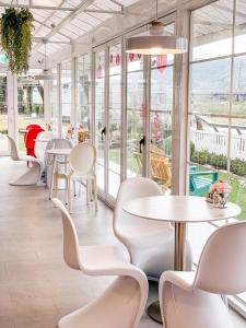 una fila di tavoli e sedie in una stanza con finestre di InnRose a Daxi