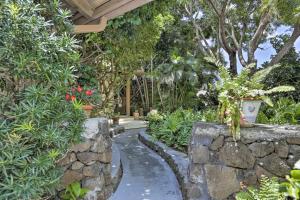 un jardin avec un mur en pierre et une passerelle dans l'établissement Cozy Honolulu Retreat with Pool Access, Near Beaches, à Waimanalo