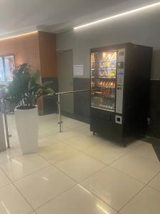a vending machine in a room with a potted plant at Lovely Rosebank 1-bedroom condo with pool & cinema in Johannesburg