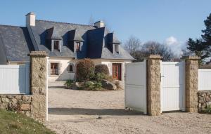 una casa con una valla blanca y una puerta en Cozy Home In Pleubian With Kitchen, en Pleubian