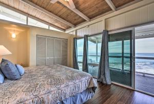 カイルア・コナにあるOceanfront Kona Home with Beach Access and Views!のベッドと大きな窓のある寝室