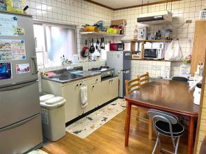 a kitchen with stainless steel appliances and a wooden table at Emix Ishigaki in Ishigaki Island