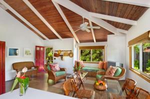 a living room with a wooden ceiling at Melemele Kapaa Cottage 1 Block to Beach! in Kapaa