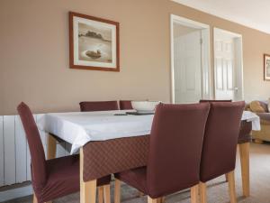 a dining room with a table with chairs and a bowl on it at Watergate Bay in Liskeard