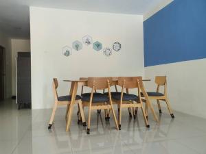 a dining room table with four chairs and a wall at Manhattan Condo Ipoh with Water Park and Pool View in Ipoh
