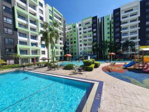a swimming pool with a playground and some buildings at Manhattan Condo Ipoh with Water Park and Pool View in Ipoh