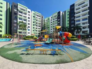 einen Spielplatz vor einem Apartmentkomplex mit Gebäuden in der Unterkunft Manhattan Condo Ipoh with Water Park and Pool View in Ipoh
