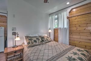 a bedroom with a bed and a wooden wall at Cozy Pahoa Hideaway Near Black-Sand Beaches! in Pahoa