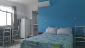 a blue bedroom with a bed and a blue wall at Residencial Tomodati in Florianópolis