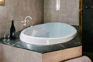 a bath tub in a bathroom with a bottle of wine at Mintaro Hideaway in Mintaro