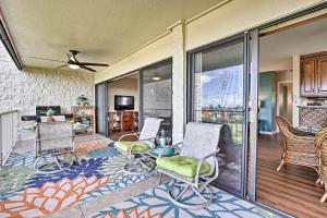 a living room with chairs and a balcony at Kailua-Kona Condo with Pool and Ocean Views in Kailua-Kona