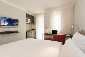 una camera con letto e scrivania con computer portatile di The Stay.residence a Monaco