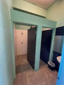 a bathroom with a shower and a toilet and a sink at The Cozy Hostel - Motel in Darwin