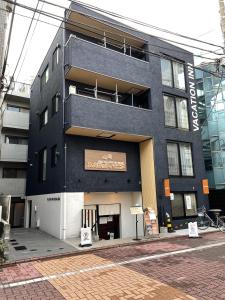 un edificio negro con un cartel en el costado en VACATION INN HEIWAJIMA I, en Tokio