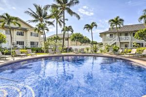 a large swimming pool with chairs and palm trees at Kapolei Condo with Lanai and Pool Access - Near Beach! in Kapolei