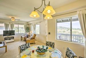 ein Wohnzimmer mit einem Tisch, Stühlen und einem TV in der Unterkunft Kapolei Condo with Lanai and Pool Access - Near Beach! in Kapolei