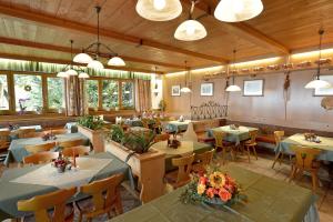 un ristorante con tavoli e sedie in una stanza di Gasthof Pension Berghof a Hippach