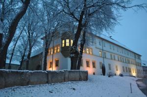 ein Gebäude mit eingeschaltetem Licht im Schnee in der Unterkunft Schlosshotel am Hainich in Behringen
