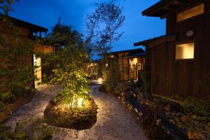 a house with a tree in the middle of a street at kominka neri（古民家煉り） in Miyawaka