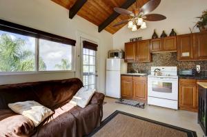 a living room with a couch and a kitchen at Cozy Kona Coast Apt with Lanai about 8 Miles to Beach! in Kailua-Kona