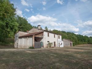 stary biały budynek siedzący na środku pola w obiekcie Authentic holiday home in Cagli with private swimming pool w mieście Acqualagna