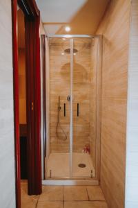 a walk in shower in a bathroom with wooden walls at Civico 9 in Brindisi