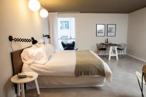 Un dormitorio con una gran cama blanca y una mesa. en Babel Studios, en Buenos Aires