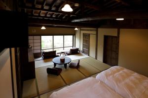 a bedroom with a bed and a living room at kominka neri（古民家煉り） in Miyawaka