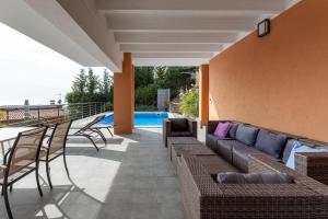 un patio con divano, sedie e piscina di holiday house in a garden with view a Lloret de Mar