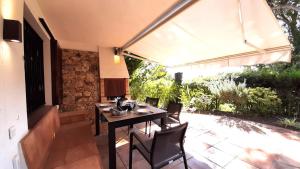 a patio with a table and chairs and an umbrella at Apartment Clip L-1 - Llafranc in Llafranc